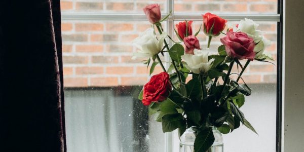 bouquet of roses in a glass vase on a windowsill